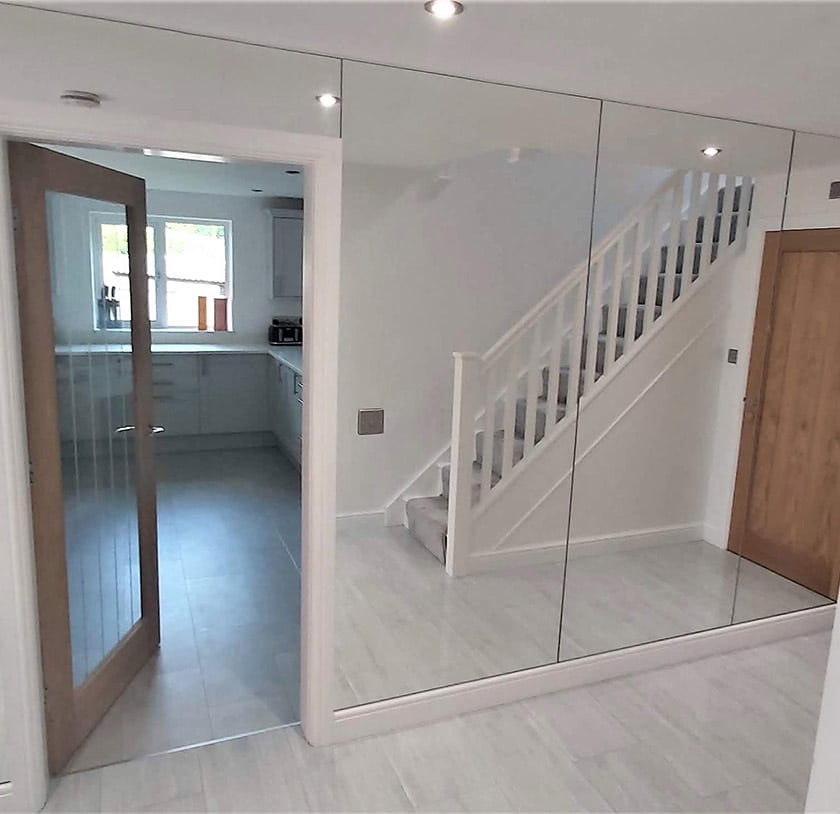 Floor to ceiling custom cut mirrors in a hallway