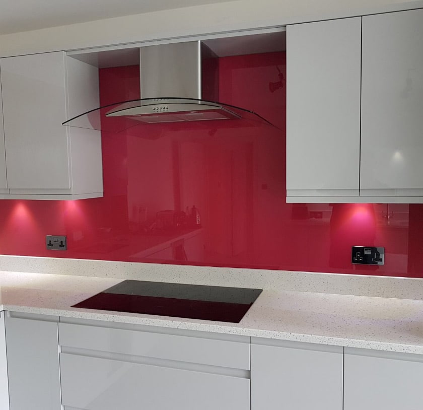 pink coloured glass splashback above kitchen countertop