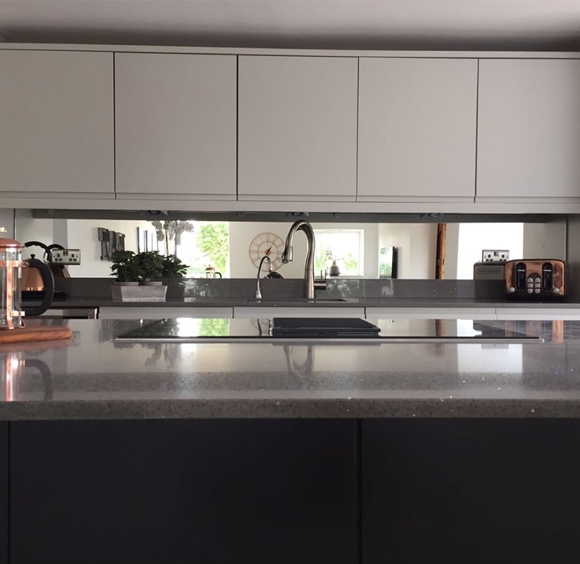 Mirrored glass splashback above kitchen countertop
