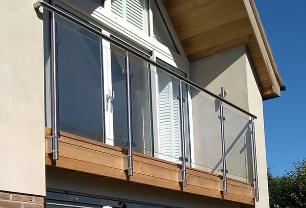 Glass balustrade with stainless steel posts and handrail along upper floor balcony