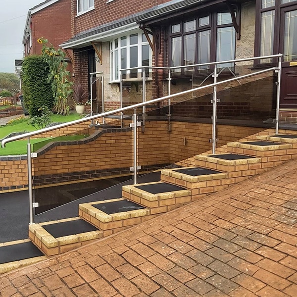 Glass balustrade with stainless steel posts and handrail along front garden steps