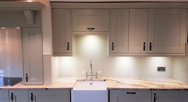 Creamy white coloured glass splashback above kitchen countertop