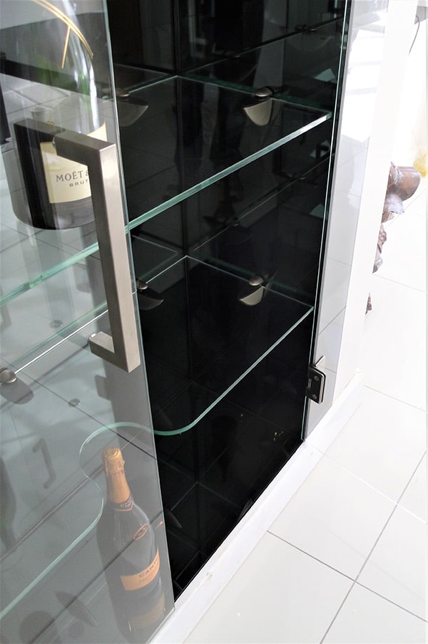 Glass shelving holding wine bottles