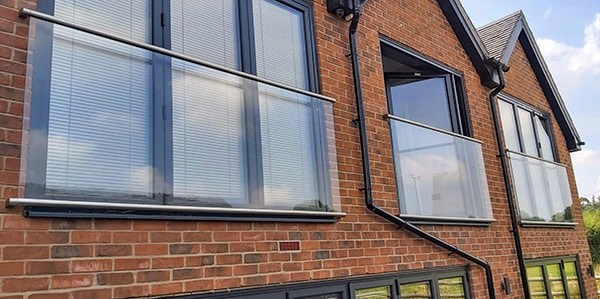 Juliet balcony with stainless steel banister across three windows and two doors