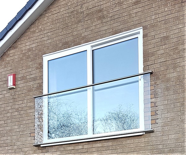 Juliet balcony with stainless steel banister across two windows
