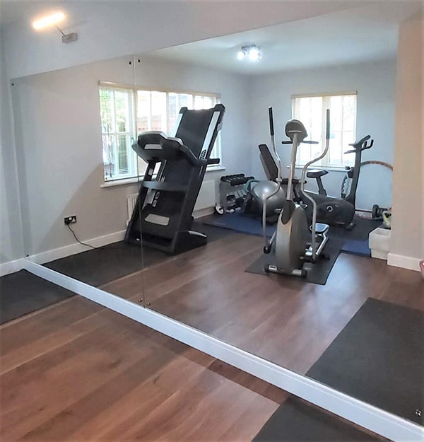Floor to ceiling mirrors reflecting gym equipment