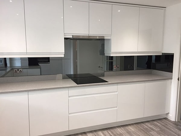 Splashback mirror above kitchen countertop and hob