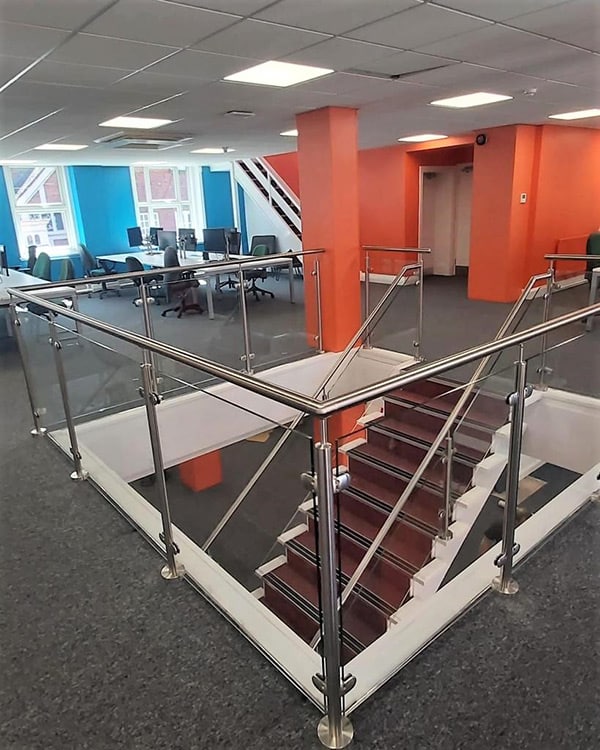Partial glass balustrade with stainless steel handrail for an office staircase