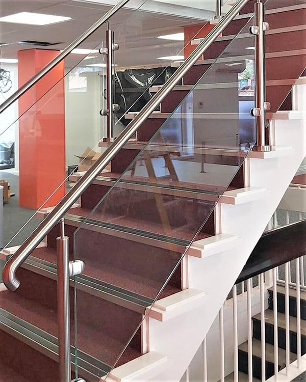 Partial glass balustrade with stainless steel handrail for an office staircase