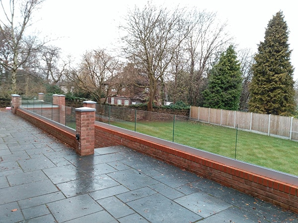 Frameless glass balustrade around a patio ang garden steps