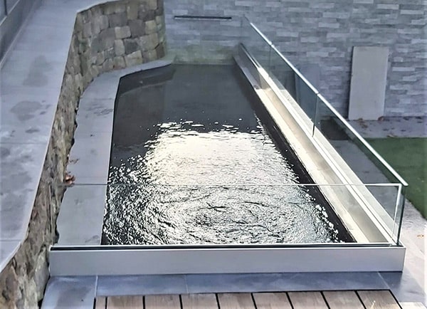 Frameless glass balustrade around an ornamental pond