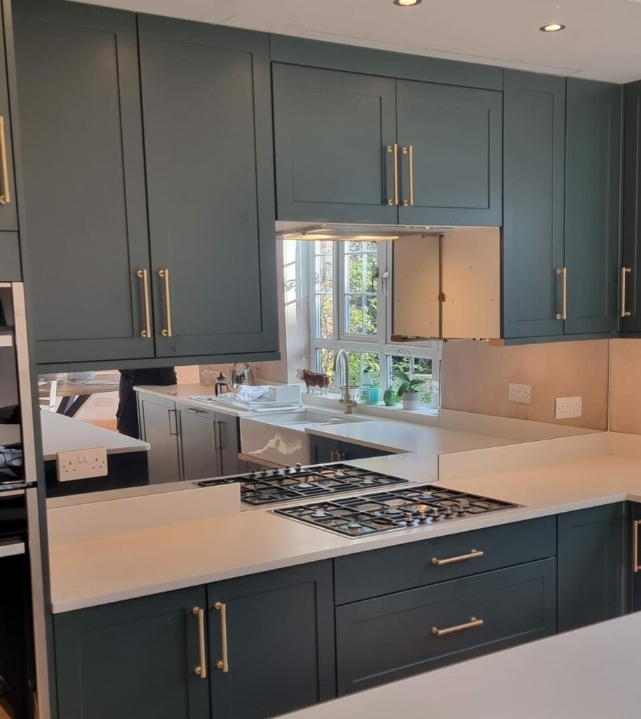 Silver mirror toughened splashback with socket cut outs across the length of a countertop