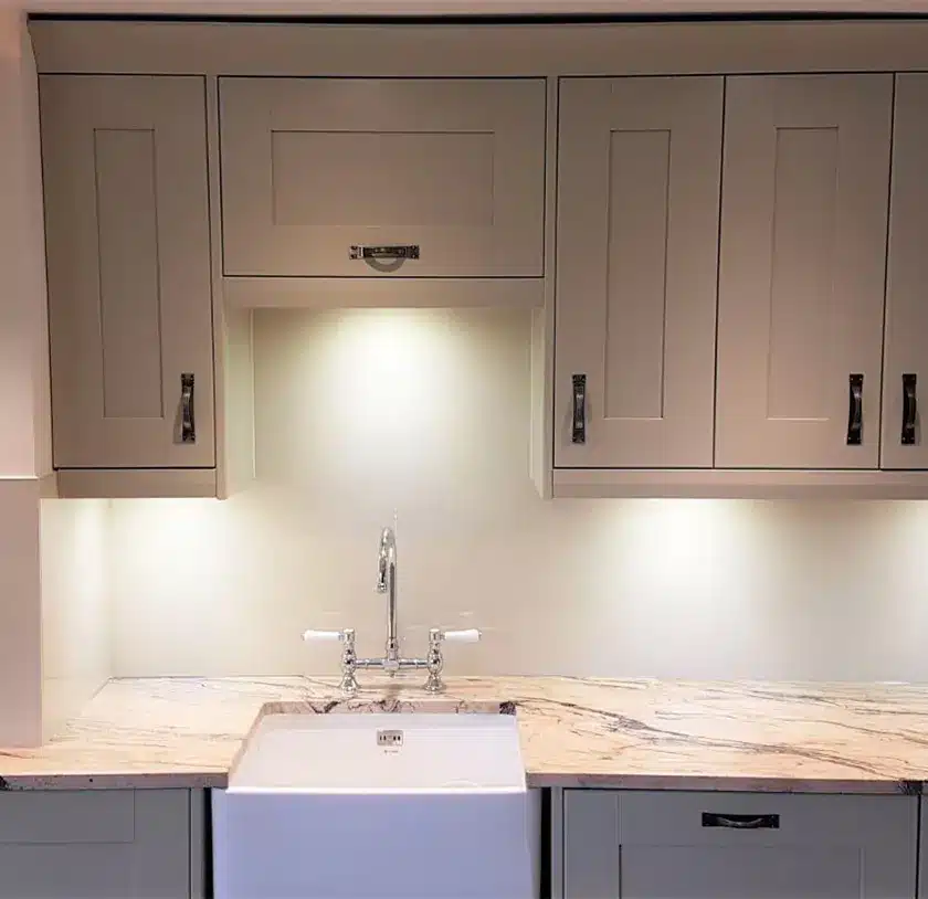 White toughened glass splashback around a porcelain kitchen sink